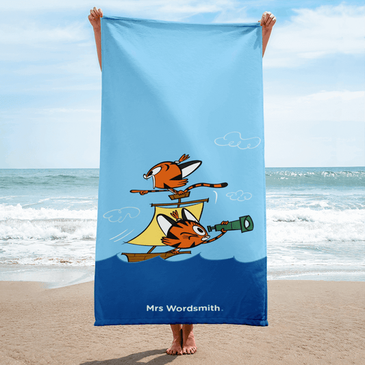 Beach towel with cartoon pirate ship on the beach.